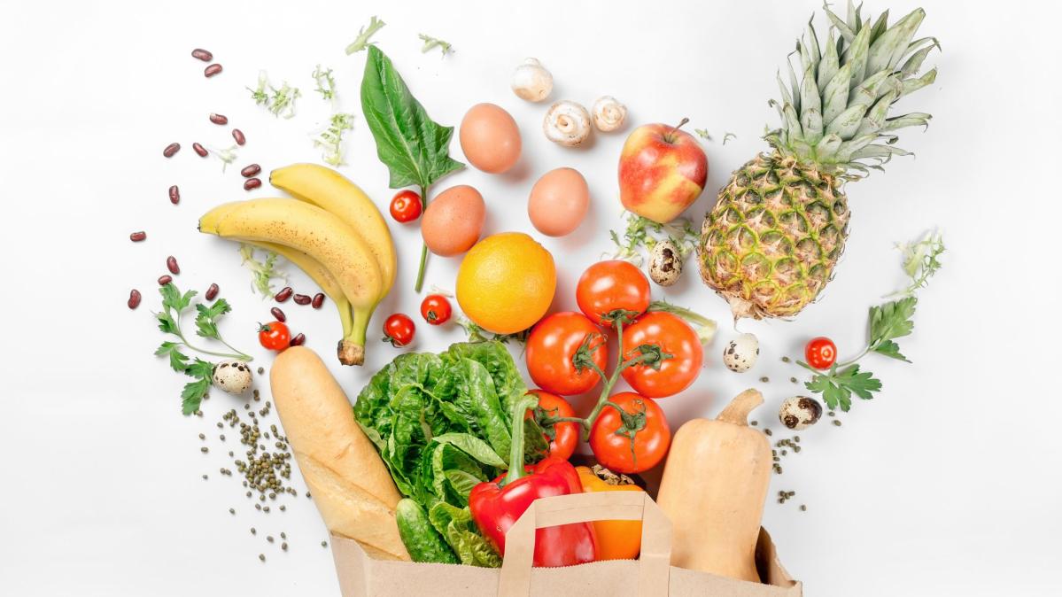 a brown bag overflowing with healthy groceries