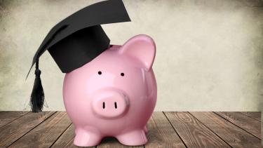 A pink piggybank wearing a graduation cap.