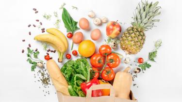 a brown bag overflowing with healthy groceries